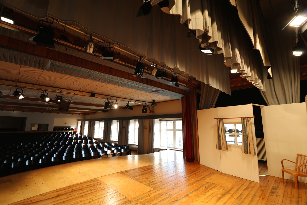 Blick von der beleuchteten Theaterbühne in den dicht bestuhlten Saal