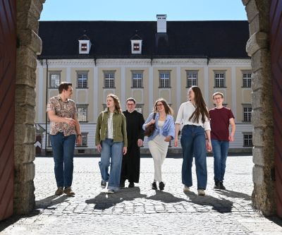 Gruppe von sechs jungen Leuten in einem Torbogen
