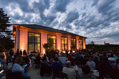 Abendveranstaltung vor dem mit Eventlicht beleuchteten Feigenhaus