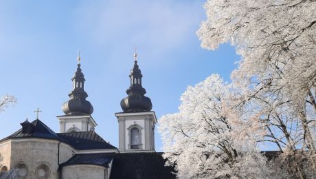 Zwei Kirchturmspitzen, blauer Himmel, winterliche Bäume